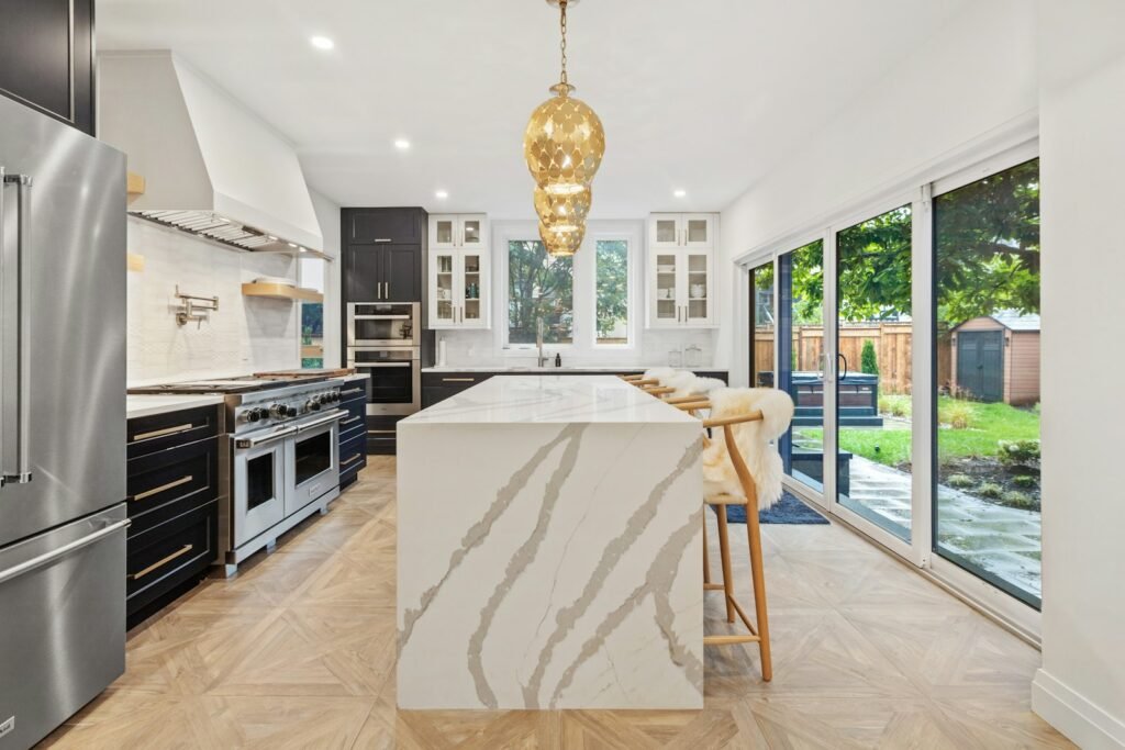 Kitchen with a marble island and gold pendant light